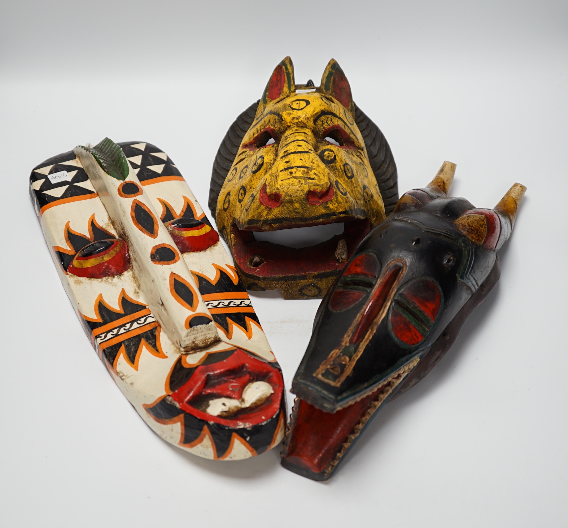 Six Indonesian tribal painted wood masks, largest 60cm high